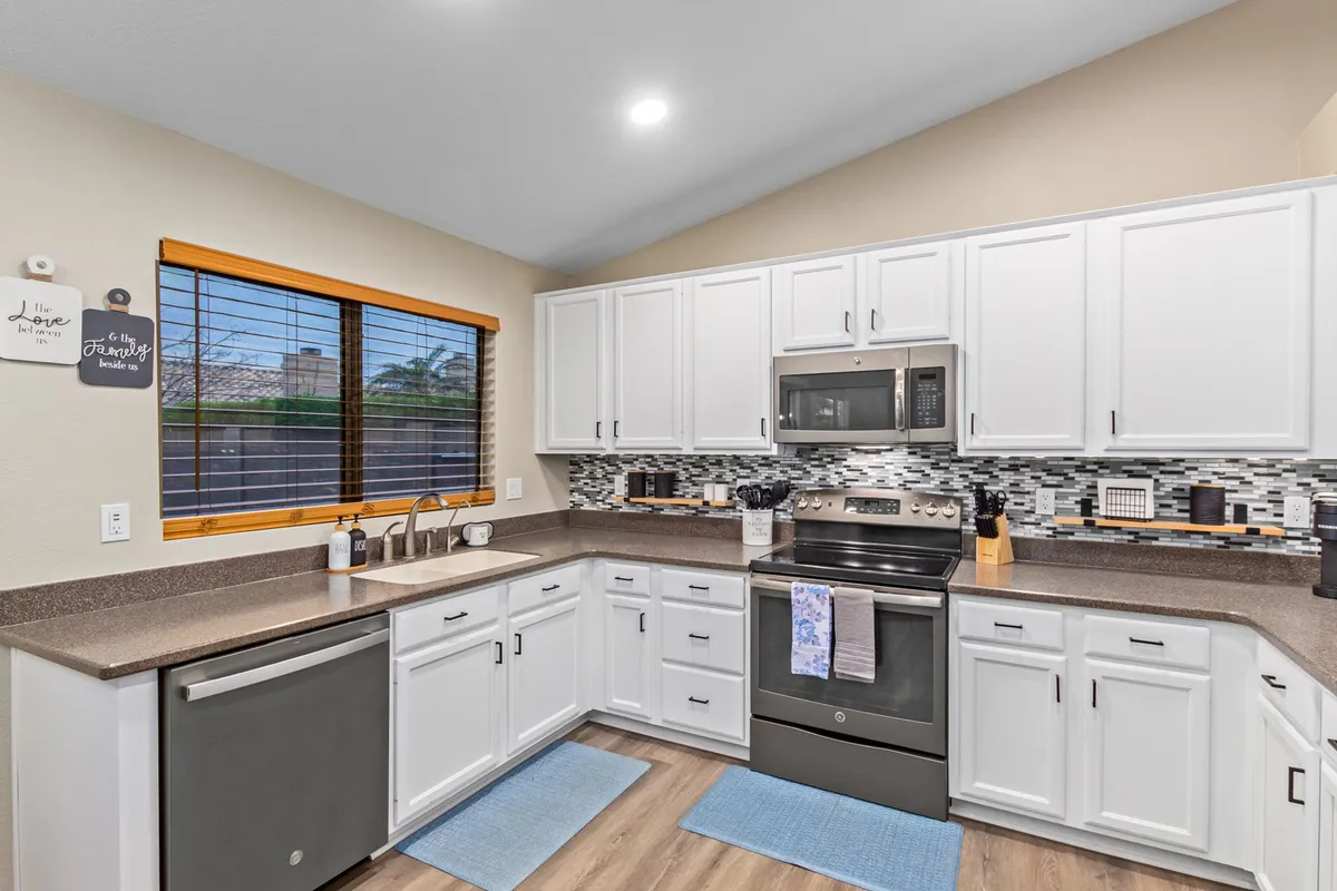 A spacious, modern kitchen with a large island, stainless steel appliances, and a window offering an outdoor view. The kitchen is designed for gourmet cooking, entertaining, or relaxed family gatherings, with ample space and high-end finishes enhancing its appeal.